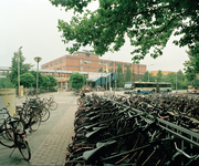 828364 Afbeelding van een groot aantal geparkeerde fietsen bij het Willem C. van Unnikgebouw van de Universiteit ...